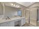 Bathroom featuring double sinks, white cabinets, and a shower over tub at 4331 Golden Palomino Ln, North Las Vegas, NV 89032