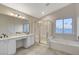 Bathroom featuring double sinks, separate shower and tub, and neutral tile flooring at 4331 Golden Palomino Ln, North Las Vegas, NV 89032