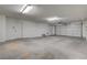 Empty two-car garage with concrete flooring, a service door, and an automatic garage door at 4331 Golden Palomino Ln, North Las Vegas, NV 89032