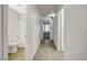 Hallway with wood-look flooring leading to a bathroom and another room with a window at 4331 Golden Palomino Ln, North Las Vegas, NV 89032