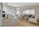 Bright living room featuring neutral tones, wood-look flooring, and an open concept design flowing into the kitchen at 4331 Golden Palomino Ln, North Las Vegas, NV 89032