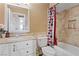 Well-lit bathroom with a tub, shower, single sink vanity, and decorative tile at 4602 Inland Ct, Las Vegas, NV 89147