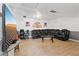 Large living room with wood look floors, featuring a large screen TV and a comfortable sectional sofa for entertainment and relaxation at 4602 Inland Ct, Las Vegas, NV 89147