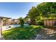 Landscaped backyard with a pool, mature trees, and well-maintained lawn at 4735 Roby Grey Way, North Las Vegas, NV 89081