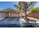 Single story home with a covered carport, mature shade tree, desert landscaping, and a brick border at 4735 Roby Grey Way, North Las Vegas, NV 89081
