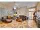 Open living room featuring patterned tile flooring, a ceiling fan, and a sliding door to the back patio at 4735 Roby Grey Way, North Las Vegas, NV 89081