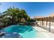 Beautiful backyard oasis with sparkling in-ground pool, lush palm trees, and secure pool fencing at 4735 Roby Grey Way, North Las Vegas, NV 89081