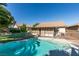 Backyard swimming pool surrounded by lush landscaping and privacy fencing at 4735 Roby Grey Way, North Las Vegas, NV 89081