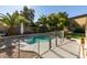 Backyard pool area with privacy landscaping, patio, and a fenced safety barrier at 4735 Roby Grey Way, North Las Vegas, NV 89081