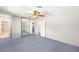 Spacious bedroom features blue carpet, fan, mirrored closet doors, and attached bathroom at 5085 Raven Ave, Las Vegas, NV 89139