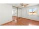 Bedroom with mirrored closet, two windows, and wood floor at 5085 Raven Ave, Las Vegas, NV 89139