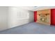 Bright living room featuring a brick fireplace, large window, and blue carpeting at 5085 Raven Ave, Las Vegas, NV 89139