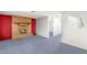 Open living room with brick fireplace, adjacent rooms, and blue carpeting at 5085 Raven Ave, Las Vegas, NV 89139