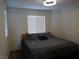 Cozy bedroom featuring a comfortable bed with gray linens, a large window, and neutral decor at 5852 Clear Haven Ln, North Las Vegas, NV 89081