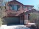 Two-story home with a gray garage door, balcony, and desert landscaping at 5852 Clear Haven Ln, North Las Vegas, NV 89081