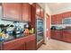 Stainless steel double oven and dark granite countertops complement cherry-wood cabinets at 5852 Clear Haven Ln, North Las Vegas, NV 89081