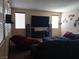 Living room with dark blue furniture, a large tv, and three windows at 5852 Clear Haven Ln, North Las Vegas, NV 89081