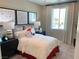 Charming bedroom with a cozy bed, stylish decor, and plenty of natural light from the window at 6511 Dove Point Pl, Las Vegas, NV 89130