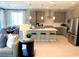 Open-concept kitchen featuring gray cabinets, stainless steel appliances, a large island, and seamless flow to the dining area at 6511 Dove Point Pl, Las Vegas, NV 89130