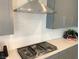 Modern kitchen featuring a gas range with stainless steel hood and stylish backsplash, perfect for culinary enthusiasts at 6511 Dove Point Pl, Las Vegas, NV 89130