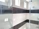 Modern shower with decorative black and white tiling and glass enclosure at 6511 Dove Point Pl, Las Vegas, NV 89130