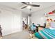 This bedroom features a ceiling fan, window, desk, chair and closet at 6624 Jade Jaguar St, North Las Vegas, NV 89086