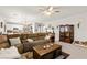 Spacious living room featuring plush seating, a ceiling fan and an adjacent, modern kitchen at 6624 Jade Jaguar St, North Las Vegas, NV 89086