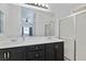 Bright bathroom with dual sinks, dark cabinets, and glass-enclosed shower at 688 Castlebridge Ave, Las Vegas, NV 89123