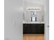 Bright bathroom with dual sinks, dark cabinets, a large mirror and a shower at 688 Castlebridge Ave, Las Vegas, NV 89123