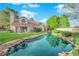 View of the home's backyard featuring a pond, a manicured lawn, and mature landscaping at 6940 Emerald Springs Ln, Las Vegas, NV 89113