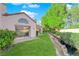 View of the home's backyard featuring a patio, a manicured lawn, and mature landscaping at 6940 Emerald Springs Ln, Las Vegas, NV 89113