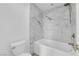 Bright bathroom featuring a marble-walled shower-over-tub and gold fixtures at 6940 Emerald Springs Ln, Las Vegas, NV 89113