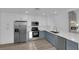 Modern kitchen boasts stainless steel appliances, quartz countertops, and stylish blue cabinets at 6940 Emerald Springs Ln, Las Vegas, NV 89113
