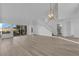 Open-concept living room with wood floors, access to the backyard, and modern lighting at 6940 Emerald Springs Ln, Las Vegas, NV 89113
