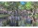 Expansive view of a neighborhood pond and the surrounding properties with mature trees at 6940 Emerald Springs Ln, Las Vegas, NV 89113