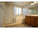 Bright bathroom features a glass door shower, a tub, and a wooden vanity with double sinks at 7715 Peaceful Trellis Dr, Las Vegas, NV 89179