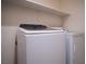 Well-equipped laundry area with a modern washer and dryer set and shelving above at 7715 Peaceful Trellis Dr, Las Vegas, NV 89179