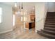 Light-filled living space with wood floors adjacent to kitchen and staircase at 7715 Peaceful Trellis Dr, Las Vegas, NV 89179