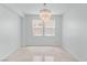 Bright dining room with chandelier and two large windows overlooking the street at 7756 River Mist Ct, Las Vegas, NV 89113