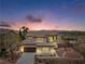 Charming two-story home with stone accents and a well-manicured front yard at dusk at 7756 River Mist Ct, Las Vegas, NV 89113