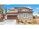 Attractive two-story home with stone accents, lush landscaping, and a two-car garage at 7756 River Mist Ct, Las Vegas, NV 89113