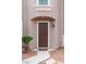 Close-up of the front door featuring an entryway alcove with a dark wooden door and manicured landscaping at 7756 River Mist Ct, Las Vegas, NV 89113