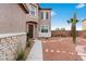 Inviting front entrance featuring desert landscaping and a dark wooden door, located on the side of the home at 7756 River Mist Ct, Las Vegas, NV 89113