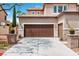 Stately two-story home with three-car garage, neutral stucco siding and manicured desert landscaping at 7756 River Mist Ct, Las Vegas, NV 89113