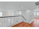 Upstairs hallway featuring wood floors and white railings at 7756 River Mist Ct, Las Vegas, NV 89113