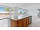 Kitchen island with sink and dishwasher overlooks the backyard through large windows at 7756 River Mist Ct, Las Vegas, NV 89113