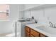 Laundry room equipped with washer, dryer, sink and overhead shelving at 7756 River Mist Ct, Las Vegas, NV 89113