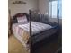 Charming bedroom with a four-poster bed, complemented by natural light from the window at 7894 W Patrick Ln, Las Vegas, NV 89113