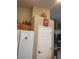 A kitchen featuring wood cabinets and white appliances next to a door at 7894 W Patrick Ln, Las Vegas, NV 89113