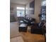 Cozy living room with comfortable black leather furniture, fireplace, and ample light at 7894 W Patrick Ln, Las Vegas, NV 89113